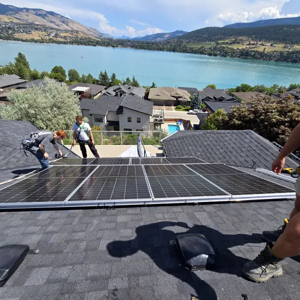 The crew laying a row of panels on a roof